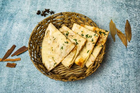 Special Masala Kulcha Naan served in a basket isolated on grey background top view of bangladesh food