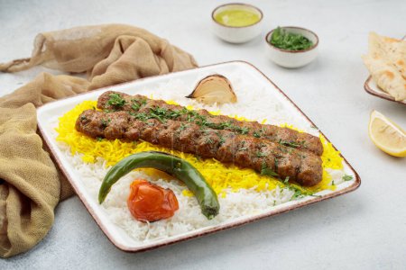Chelo or Chelow Kabab with rice, tomato and lime served in dish isolated on table top view of arabian food