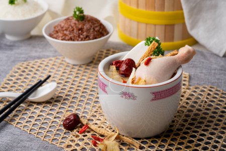 SOUP DE POULET HERBAL avec cuillère servie dans un pot chaud isolé sur la table vue du dessus de la nourriture singapore