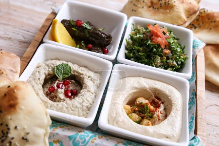 Téléchargez les photos : Plateau de mezza classique avec Baba Ganoujm, Salsa turque, Labneh, Taboula et feuilles de vigne servi dans un plat isolé sur le dessus de fond de mezza froide alimentaire arabe - en image libre de droit