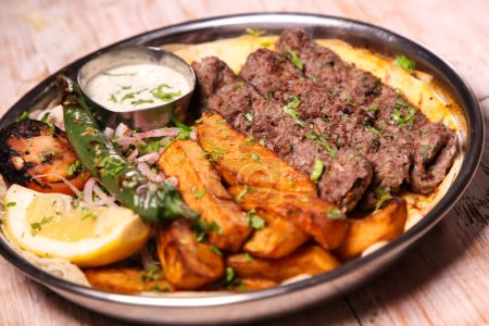 Foto de Kebab Laham o kabab de cordero con ensalada, cuñas, limón y salsa servidos en plato aislado en el fondo vista superior de la comida árabe - Imagen libre de derechos