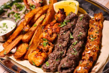 Foto de Surtido de parrillas de mezcla con pollo tikka, kabab de res, kebab de cordero, alas, boti, malai, tawook shish servido en plato aislado en la vista superior de fondo de la comida árabe - Imagen libre de derechos