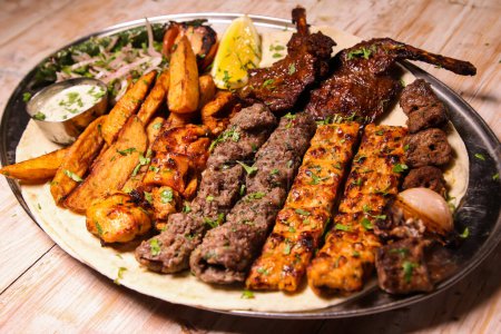 Verschiedene Mischung Grills mit Huhn Tikka, Rindfleisch Kabab, Hammelfleisch Kebab, Flügel, boti, malai, hacken, shish tawook serviert in Gericht isoliert auf dem Hintergrund Draufsicht auf arabische Lebensmittel