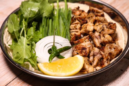 Foto de Pollo tikka Dajaj con ensalada, cuñas, limón y salsa servido en plato aislado sobre fondo vista superior de la comida árabe - Imagen libre de derechos