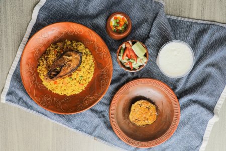 Hilsa Khichuri Combo mit Salat, Auberginen, Borhani und boondi rabi serviert in Gericht isoliert auf Matte Draufsicht auf indische und bangladeshi Essen