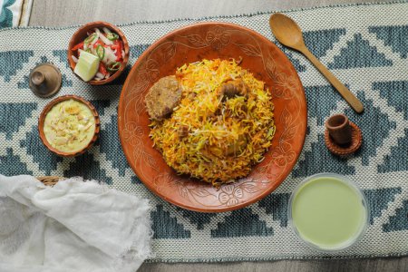 Foto de Mutton Kacchi biryani con ensalada, borhani y Chui Pitha servido en plato aislado en la estera vista superior de la comida india y bangladeshi - Imagen libre de derechos