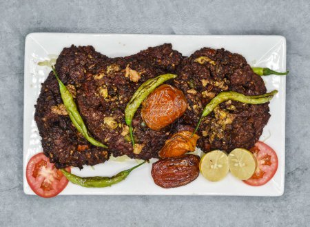Photo for Chapli kabab withlemon and tomato served in dish isolated on background top view of indian spices and pakistani food - Royalty Free Image