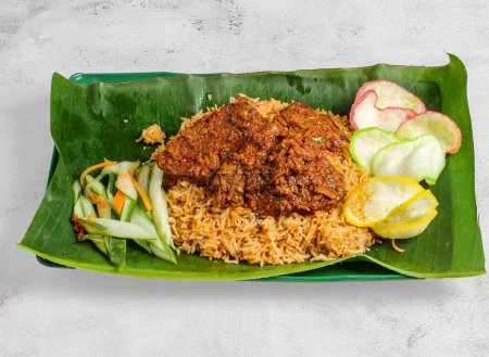Téléchargez les photos : Riz biryani de boeuf ou pulao avec salade servie dans un plat isolé sur une feuille de banane vue du dessus de la nourriture singapore - en image libre de droit