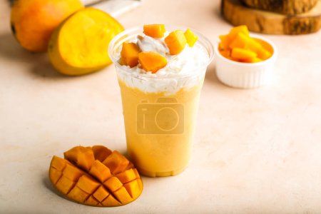 milkshake à la mangue avec de la crème et des tranches de fruits crus servis dans un verre isolé sur la table vue du dessus boisson saine du matin