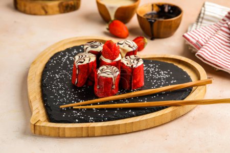 Foto de Redterciopelo Sushi Crepe roll con fresa, palillos y chocolate servido en plato aislado en la mesa vista superior de la cafetería postre de alimentos - Imagen libre de derechos