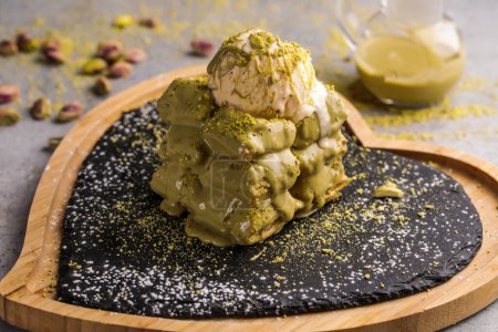 Téléchargez les photos : Gaufre aux pistaches avec cuillère à crème glacée servie dans un plat isolé sur la table vue sur les gaufres du café dessert alimentaire - en image libre de droit