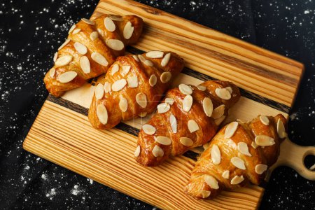 Photo for Almond Croissant topping with nuts served on wooden board top view of french breakfast baked food item - Royalty Free Image