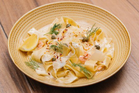 Téléchargez les photos : Nouilles Pappardelle al Salmone ou Tagliatelle au citron servi dans une assiette isolée sur la table vue de côté de la nourriture italienne rapide - en image libre de droit