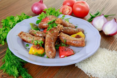 Photo for Grilled mumbar or sausage grill with onion, tomato and coriander served in dish isolated on table side view of arabic food - Royalty Free Image