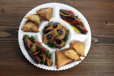 Photo for Mix hot appetizers platter with crispy chicken, samosa and Grilled mumbar sausage served in dish isolated on table top view of arabic food - Royalty Free Image