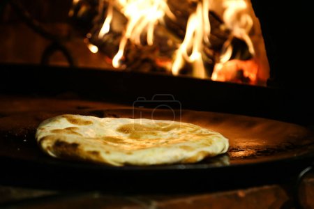 Foto de Pan sin levadura servido en tabla de madera aislado en la vista lateral de la mesa de comida árabe - Imagen libre de derechos