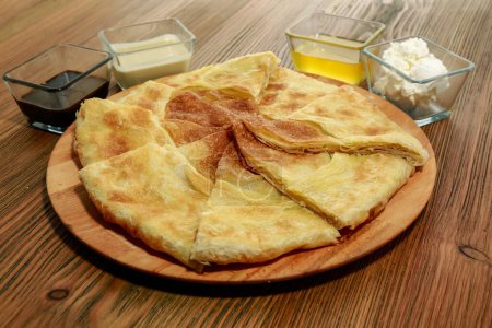 Foto de Pan sin levadura con inmersión servido en tablero de madera aislado en la vista lateral de la mesa de comida árabe - Imagen libre de derechos