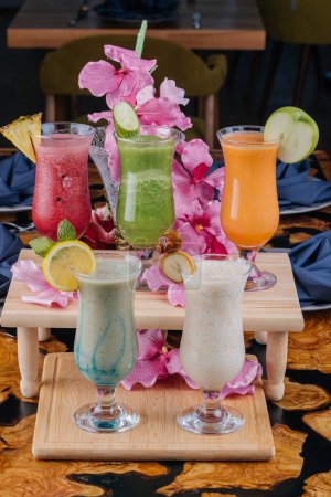 Foto de Batido de plátano y dátiles, fruta de la pasión, jugo de naranja y pepino servido en vidrio aislado en la vista lateral de la mesa de la bebida árabe saludable por la mañana - Imagen libre de derechos