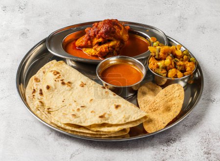 Téléchargez les photos : Ensemble de thali de poulet avec korma de poulet, mélange de légumes d'aloo gobi matar, shorba et chapati servi dans un plat isolé sur fond vue de dessus de la nourriture épicée indienne - en image libre de droit