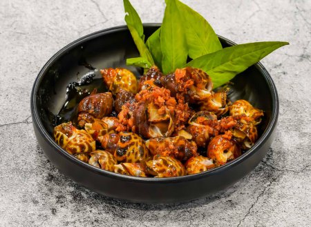 Téléchargez les photos : Escargots salés ou oc huong muoi tac, botoi servi dans un plat isolé sur fond gris vue de dessus de fruits de mer singapore - en image libre de droit