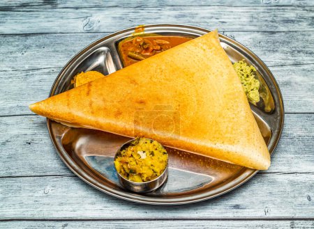 Foto de Masala dosa thali conjunto con sabji y chutney servido en plato aislado en madera mesa vista superior de la comida picante india - Imagen libre de derechos