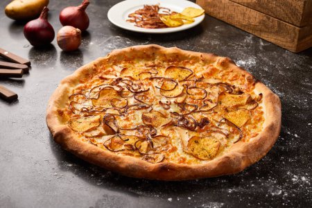 Feuertorte Pizza mit Zwiebeln und Cracker isoliert auf dunklem Hintergrund mit Rohkost Draufsicht auf italienische Fastfood-Vorspeise