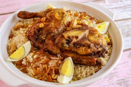 chicken Mandi Biryani Pulao rice with boiled egg served in pot dish isolated on wooden table top view arabic spicy food