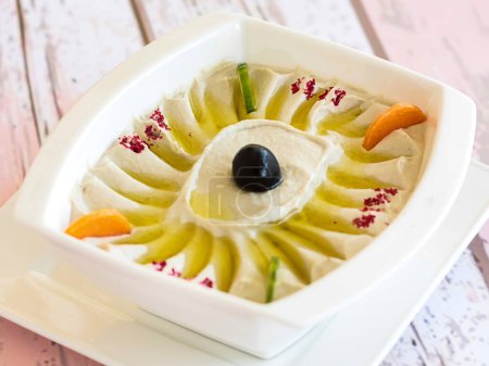 MOUTABEL mit Olivenöl, Karotten und Gurken, serviert in Schale isoliert auf hölzerner Tischplatte Blick auf kalte Mazza-arabische Speisen