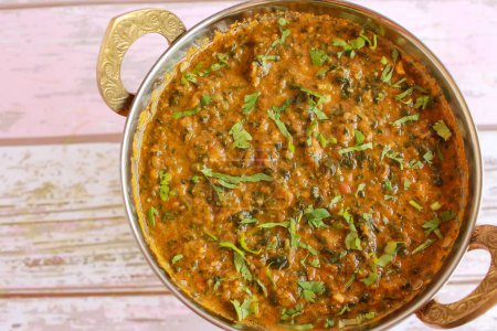 Mutton Palak Gosht Korma served in karahi isolated on table closeup top view of indian spices food