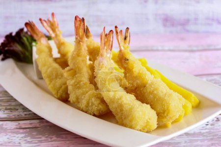 PRAISES TEMPURA frites servies dans un plat isolé sur table vue rapprochée du dessus de fruits de mer grillés
