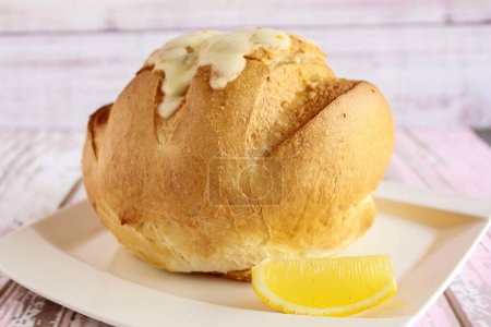 Téléchargez les photos : Soupe dans le bol à pain avec tranche de citron servie isolée sur la table vue rapprochée du dessus de la soupe chaude - en image libre de droit