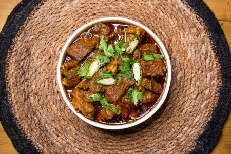 Rindfleisch Mezbani Gosht korma karahi serviert in Gericht isoliert auf hölzernem Hintergrund Draufsicht indische Gewürze, bangladeshi und pakistanisches Essen