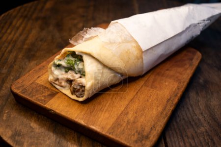 Téléchargez les photos : Rouleau de shawarma de poulet classique enveloppé servi isolé sur une planche de bois vue de dessus nourriture épicée arabe - en image libre de droit