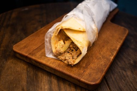 Téléchargez les photos : Emballage rouleau shawarma de poulet arabe servi isolé sur une planche de bois vue de dessus fastfood épicé arabe - en image libre de droit