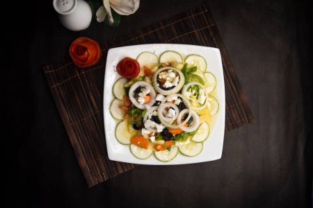 classic Greece salad with cucumber, onion, tomato, olive, carrot and feta cheese served in dish isolated on napkin mat top view of healthy supper food