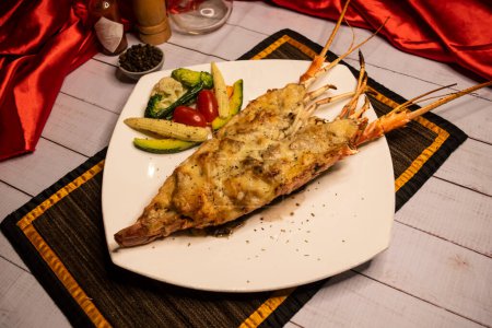 Whole Lobster Thermidor lobster cream sauce with salad, chilli sauce and black pepper served in dish isolated on napkin top view on wooden table italian food
