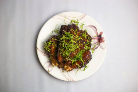 Grill Chicken topping with coriander served in plate isolated on background top view of bangladeshi, indian and pakistani traditional spicy food
