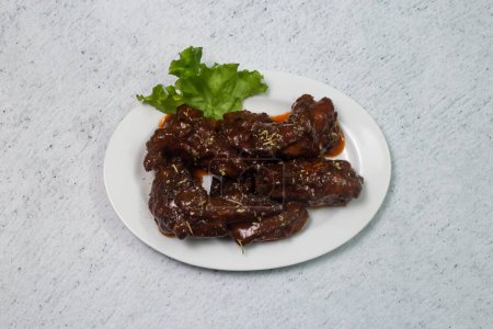 Naga chicken wings served in dish isolated on grey background top view of bangladeshi fastfood