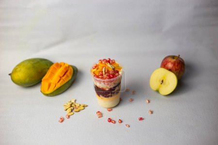 Photo for Faluda with fruits, apple, mango and pomegranate seeds served on glass isolated on grey background side view of indian, bangladeshi and pakistani dessert - Royalty Free Image