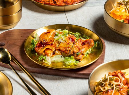 Téléchargez les photos : Jambon de poulet grillé Andong avec chou, cuillère et baguettes servi dans un plat doré isolé sur une planche de bois vue de côté de la nourriture kong kong - en image libre de droit