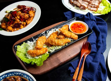 Foto de Filete de pescado crujiente con cuchara de salsa de chile y tenedor servido en un plato aislado en una tabla de madera vista lateral de la comida taiwan - Imagen libre de derechos