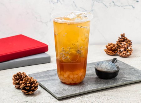 Photo for Han Tian Ai Jade Little Perilla iced tea served in disposable glass isolated on board side view of taiwanese iced drink - Royalty Free Image