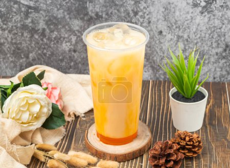 Téléchargez les photos : Thé glacé aux fruits de la passion Yakult avec glaçon servi en verre jetable isolé vue de côté de la table n de boisson taïwanaise - en image libre de droit