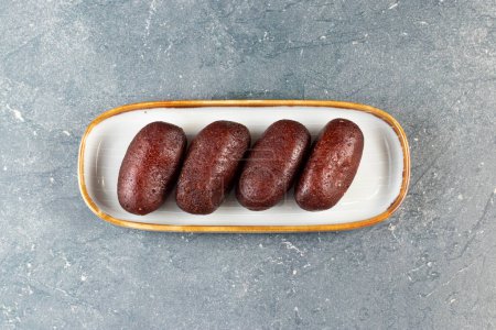 Gulab Jamun, kalo jam or mohan served in tray dish isolated on grey background closeup top view of indian, pakistani and bangladeshi sweet food