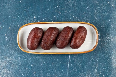 Gulab Jamun, kalo jam or mohan served in tray dish isolated on navy background top view of indian, pakistani and bangladeshi sweet food