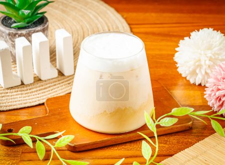 Taiwan iced Fresh Milk Tea served in glass isolated on wooden table side view of Taiwan drink