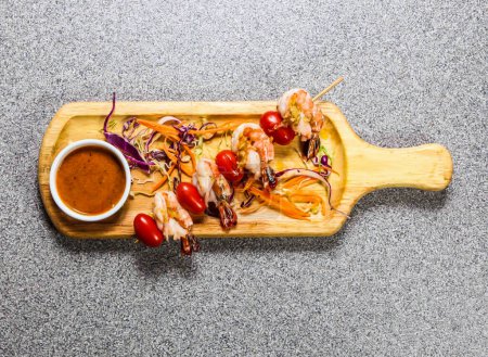 Jumbo Shrimp Ball Satay Skewers with chilli sauce served on wooden bard isolated on grey background top view of hong kong fastfood