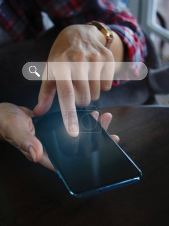 Téléchargez les photos : Main tenant un smartphone pour utiliser la barre de recherche trouver des données d'information et plus sur Internet - en image libre de droit