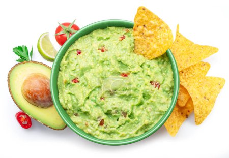 Guacamole sauce, its ingredients tortilla chips, popular Mexican food  top view on white background.
