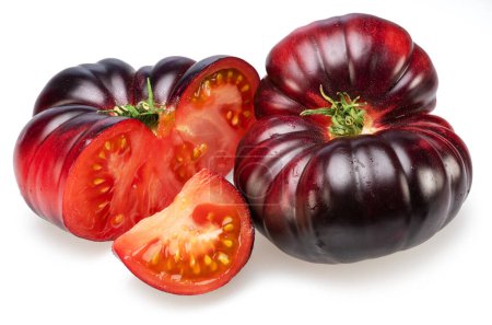 Reife schwarze oder lila Tomaten und Tomatenscheiben isoliert auf weißem Hintergrund. 